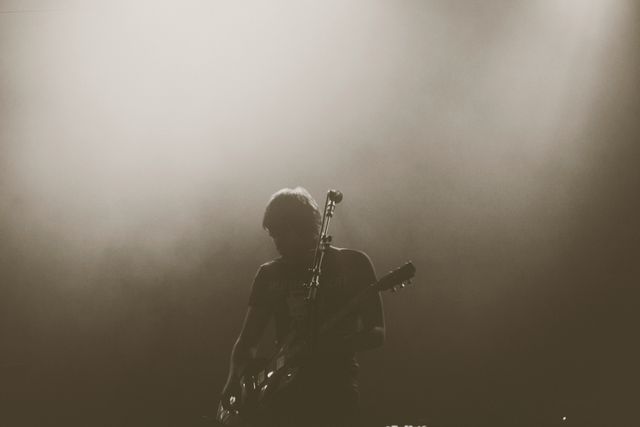 Silhouette of Guitarist Performing on Stage with Moody Lighting - Download Free Stock Images Pikwizard.com