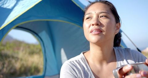 Woman Enjoying Refreshing Drink During Outdoor Camping Adventure