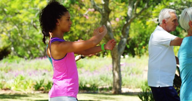 Group of people practicing Tai Chi in a park, perfect for promoting mindfulness, healthy lifestyle, fitness and wellness programs. It captures the essence of outdoor group exercise, which is ideal for blogs, advertisements for fitness programs, and social media posts promoting health and relaxation.