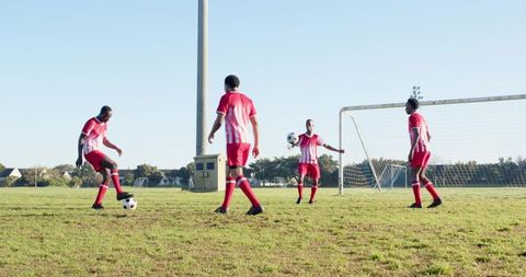 African American Male Athletes Practicing Soccer on Grassy Field