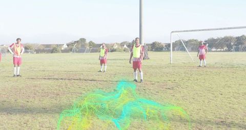 Amateur soccer players training on suburban field wearing neon bibs and red-white kits