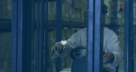 Forklift operator steering controls in warehouse aisle, hands on levers, industrial logistics