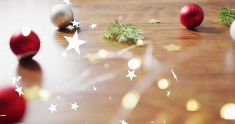 Festive tabletop styling with red baubles, glowing fairy lights and gold star confetti