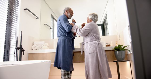 Senior Couple Laughing and Dancing in Bathroom Wearing Robes - Download Free Stock Images Pikwizard.com