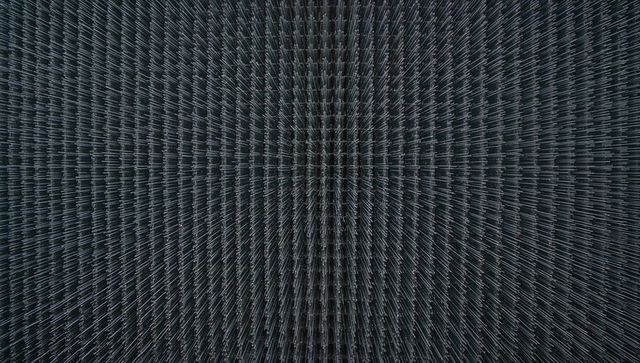 Dense metallic fin lattice converging toward central seam — symmetrical industrial texture