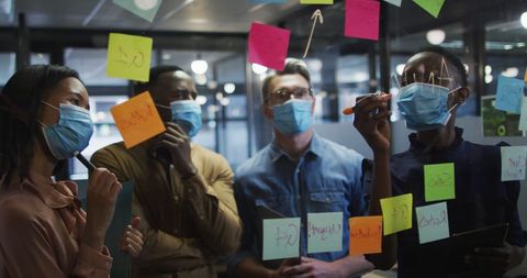 Masked Professionals Collaborating in Office Space