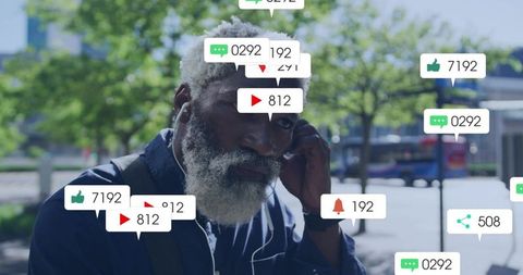 Mature man listening with earbuds on urban sidewalk amid social media notification icons