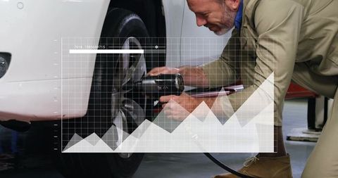 Mechanic Kneeling Tightening Car Wheel with Air Gun, Workshop Maintenance Metrics Overlay