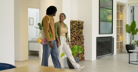 African American Couple Walking Hand in Hand Through Modern Minimalist Living Space