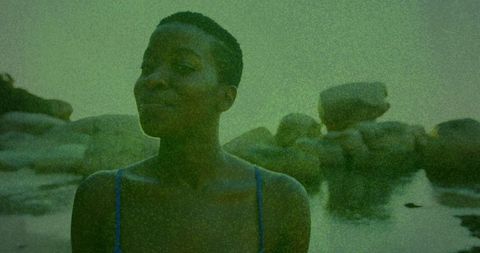 Woman contemplates in coastal tide pool serenity