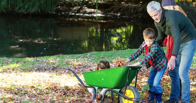 Family Enjoying Autumn Cleanup Outdoors Near Pond - Download Free Stock Images Pikwizard.com