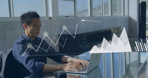 Businessman Analyzing Financial Data on Laptop in Modern Office