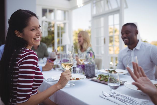 Smiling woman having wine during lunch in restaurant