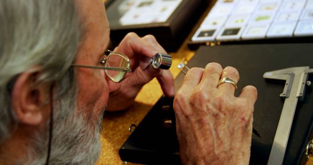 Jeweler Examining Diamond with Magnifying Glass in Workshop - Download Free Stock Images Pikwizard.com