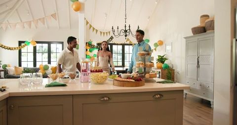 Diverse Friends Setting Up Birthday Party in Bright, Festive Living Room