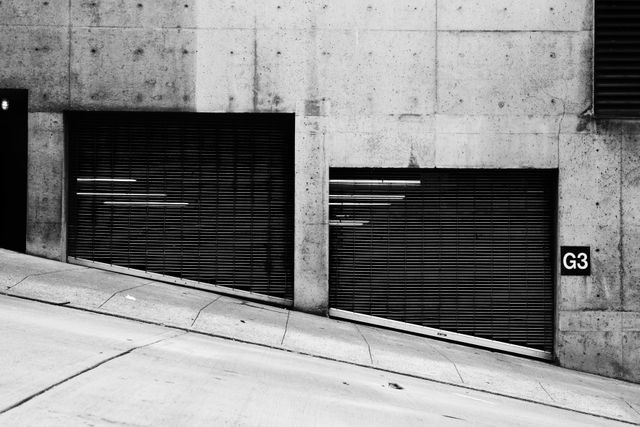 Urban slope with closed garage doors black and white street scene - Download Free Stock Photos Pikwizard.com
