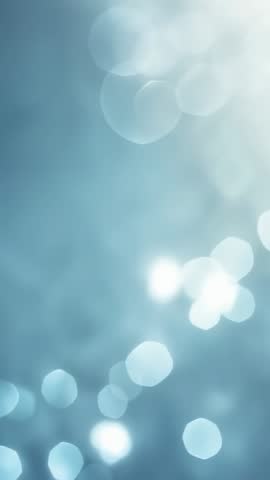 Drifting vertical bokeh orbs over blue gradient with soft glowing light