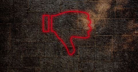 Neon red thumbs down symbol on grunge wall background