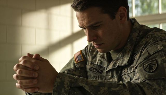 Contemplating u.s. Army soldier clasping hands in barracks with robson name tape