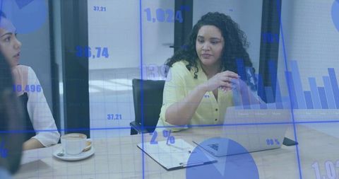 Businesswoman leading analytics discussion in modern boardroom with laptop and charts