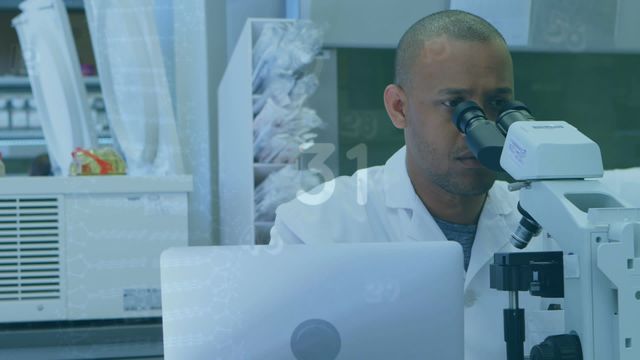 Video shows an African American male scientist using a microscope in a modern laboratory with scientific data and counting animation overlay. Perfect for content related to technological advancements in scientific research, educational materials about laboratory procedures, and promotional materials for health and science sectors.