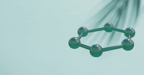 Molecule model spinning over leaf shadow on green
