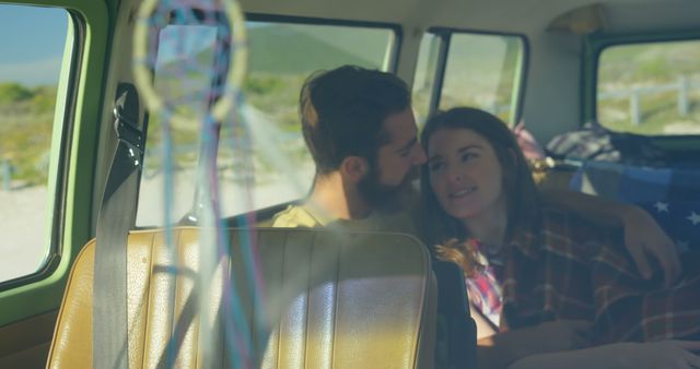This image depicts a couple embracing in the back of a vintage van during a road trip. The cozy setting suggests a romantic adventure and freedom, making it perfect for use in travel, adventure, lifestyle, and romance campaigns. Ideal for illustrating romantic getaways, scenic travel destinations, and the joys of life on the road.