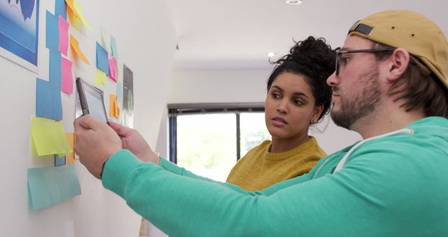 Collaborating creative team brainstorming with sticky notes on wall - Download Free Stock Images Pikwizard.com