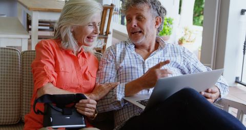 Joyful Senior Couple Using Laptop and VR Headset in Living Room - Download Free Stock Images Pikwizard.com