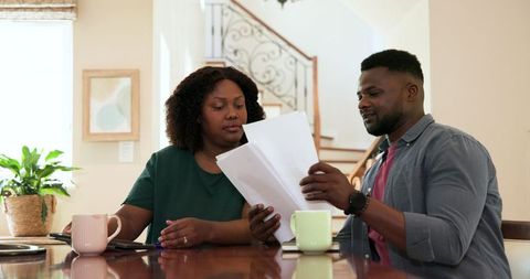 African American Couple Discussing Documents in Home Setting