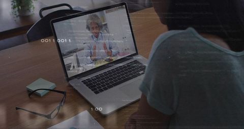 Remote mentoring session showing older female presenter on laptop while attendee watching
