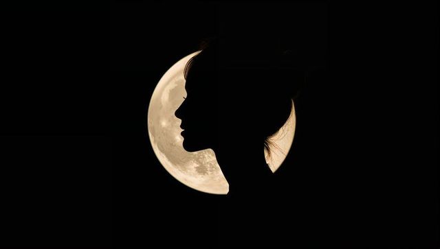 Silhouette of Woman with Moonlit Background Displaying Tranquility