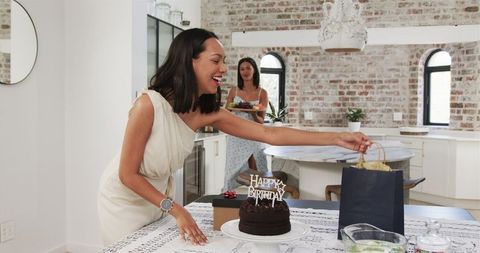 Friends preparing for birthday celebration with cake and gifts at home