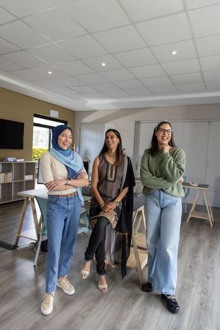 Multicultural female coworkers collaborating and smiling in modern office space