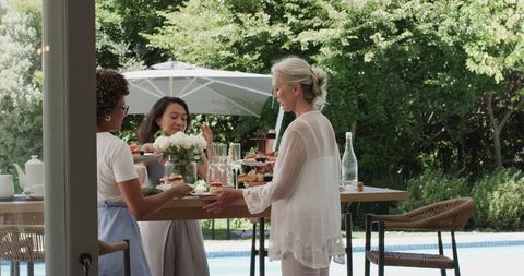Women Enjoy Outdoor Brunch by Pool in Relaxed Gathering
