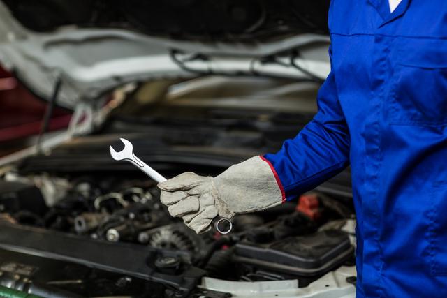 Mechanic Holding Wrench in Auto Repair Garage - Download Free Stock Photos Pikwizard.com