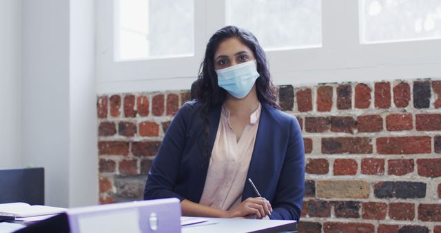 Confident Businesswoman Wearing Mask in Modern Office Environment - Download Free Stock Images Pikwizard.com