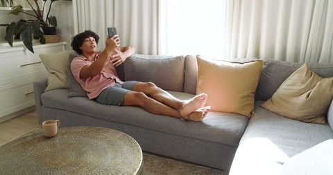 Relaxed Man Taking Selfie on Sofa in Modern Living Room