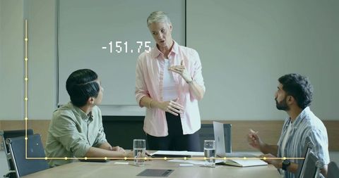 Businesswoman Presenting Data Analysis to Team in Meeting Room