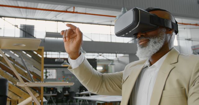 Senior man wearing VR headset, immersed in virtual experience within modern office setting. Perfect for depicting futuristic technology, aging adults using tech, and professional settings. Great for articles, websites, and presentations on innovation, technology adoption among seniors, and workplace advancements.