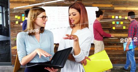 Women Collaborating in Modern Office Brainstorming by Whiteboard and Planning Wall
