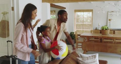 Happy Family Arriving in Modern Home with Beach Ball