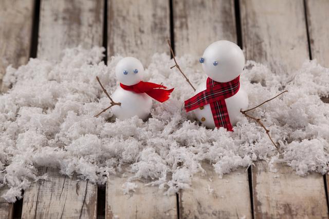 Close-up of two snowman with fake snow
