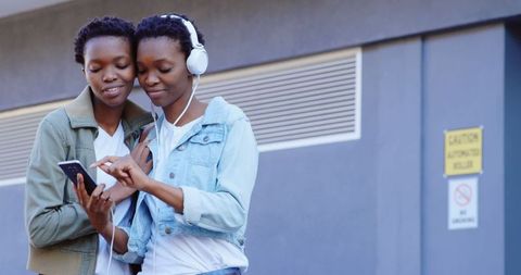 African American Twin Sisters Sharing Music in Urban Setting