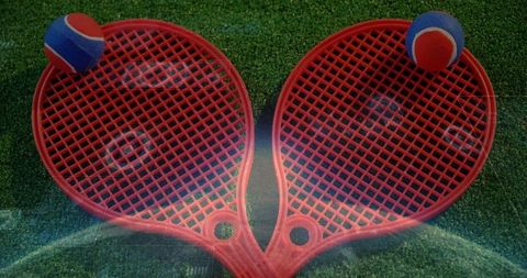 Red heart-shaped rackets on turf with foam balls