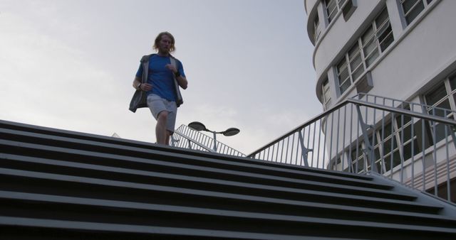 Man Walking Down Urban Staircase with Modern Architecture - Download Free Stock Images Pikwizard.com