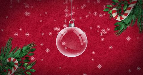 Festive christmas bauble with candy canes on red background