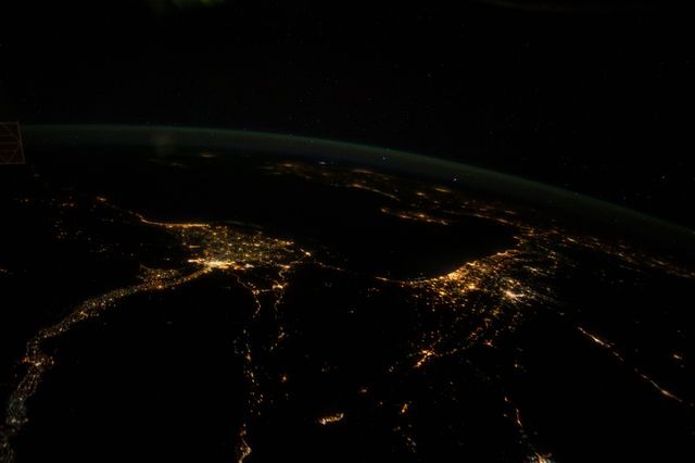 This image showcases a nighttime aerial view of Middle Eastern cities illuminated as seen from the International Space Station. The bright urban areas contrasting against the dark landscape create a stunning visual effect. Ideal for use in space exploration articles, geography studies, urban development discussions, and nightscape photography collections.