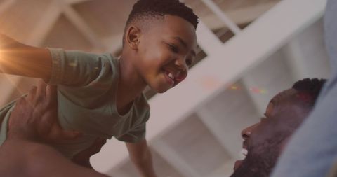 Joyful African American Father and Son Playing at Home