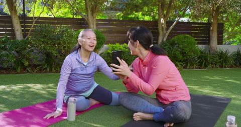 Asian women exercising outdoors while enjoying social interaction